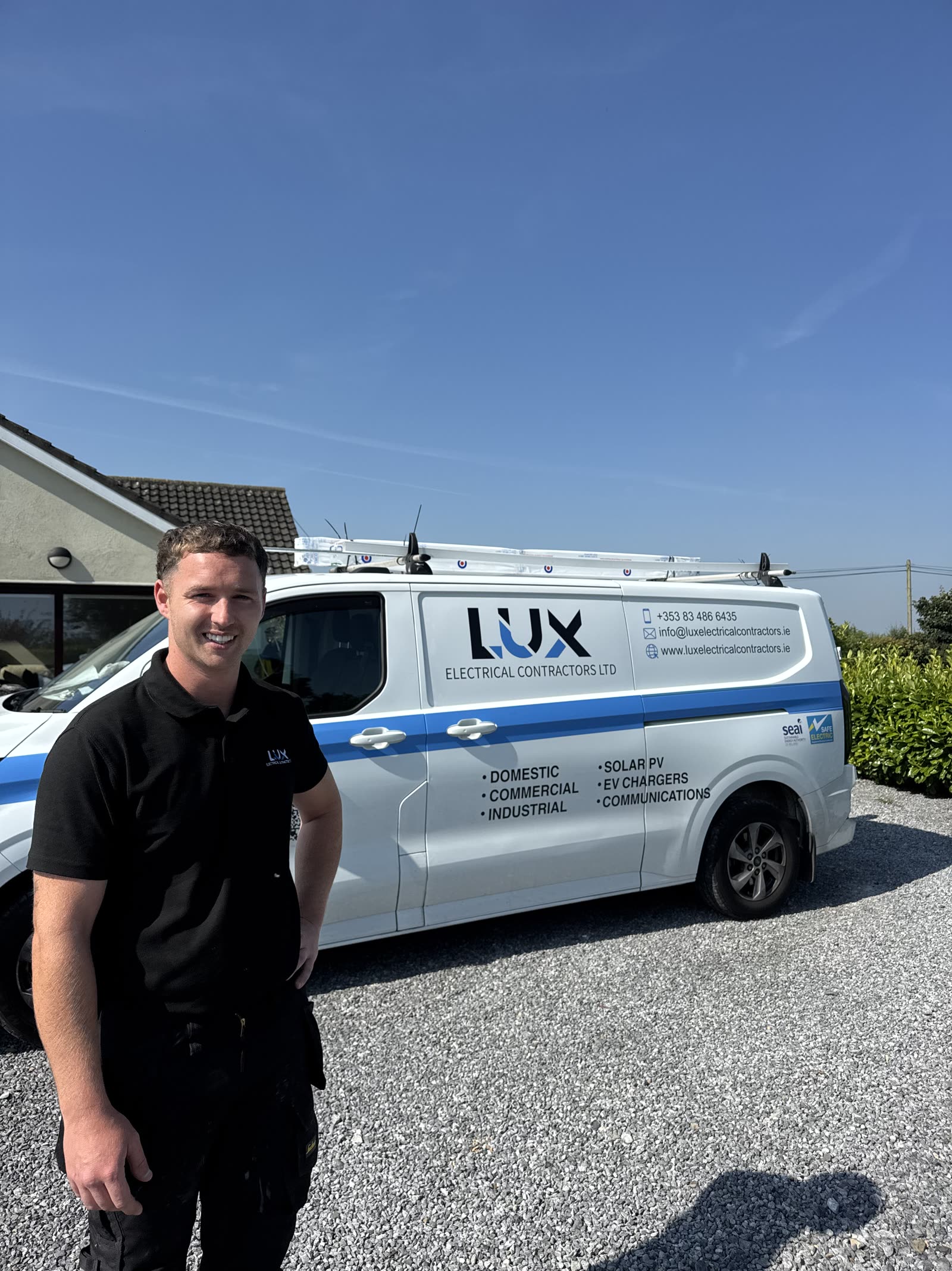 Dean from Lux beside a branded van after a solar install
