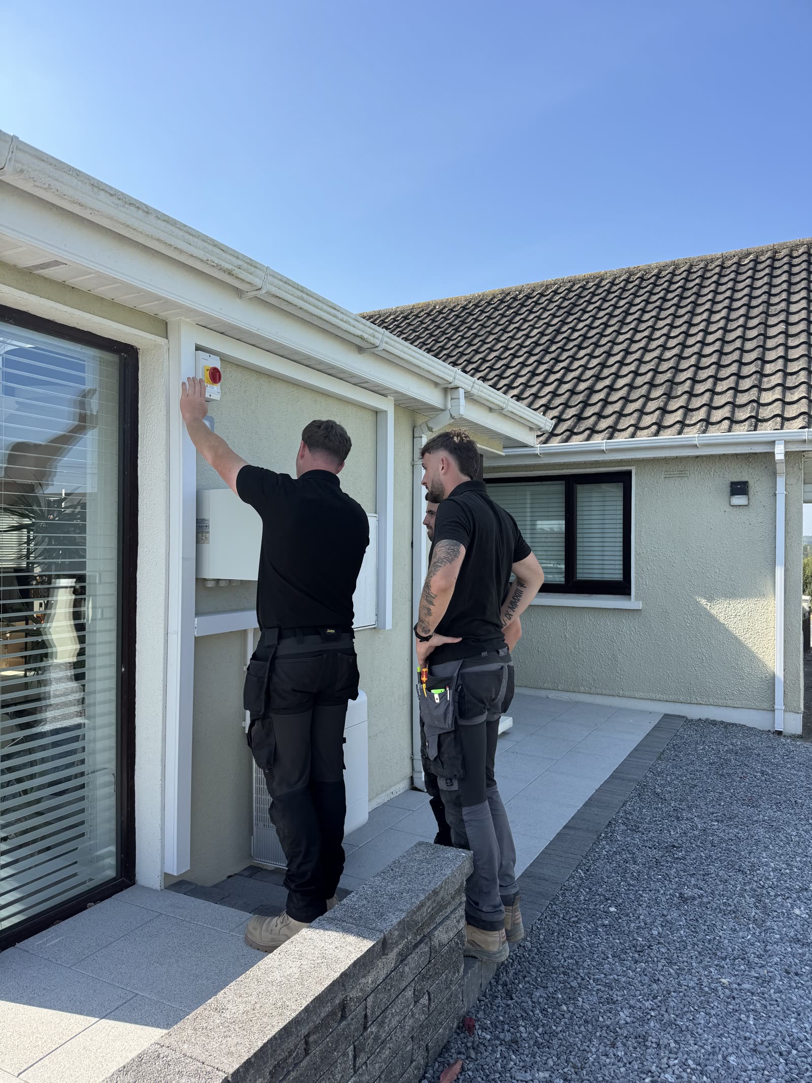 Lux installers commissioning a solar isolator at a home
